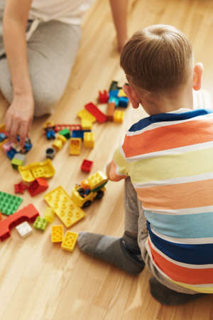 Boy in colorful t-shirt playing toys at homeの写真素材