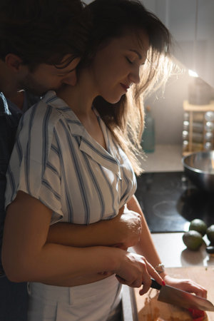 Young couple cooking tasty dinner together in a kitchenの写真素材