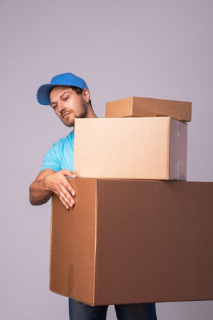 Happy delivery man during work with a packages in a cardboard boxes