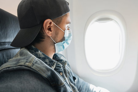 Man wearing prevention mask during a flight inside an airplane