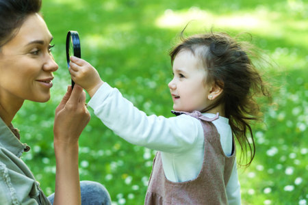 Mother and daughter playing with a magnifierの写真素材