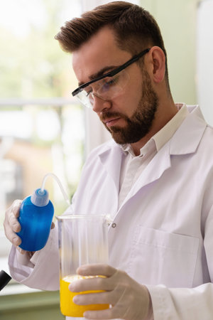Scientist pouring water into the beaker in a laboratory during research