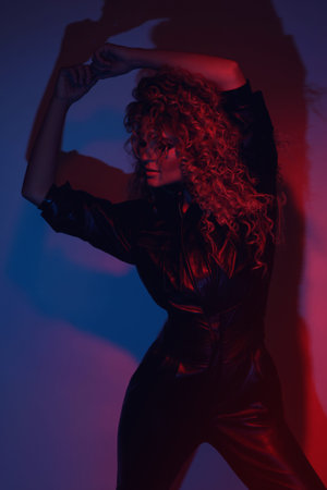 Young and sexy woman with a stylish Afro hairstyle wearing leather biker suit