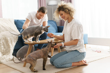 Happy caucasian couple and their cute cats at home