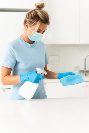 Woman worker wearing prevention mask and gloves during apartment cleaningの写真素材