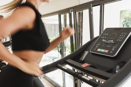 Athletic woman running on treadmill during fitness workout