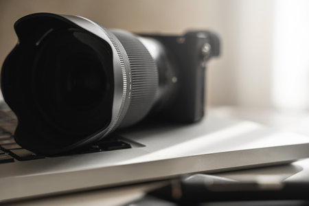 Photographers workplace with a mirrorless camera, laptop and graphics tabletの写真素材