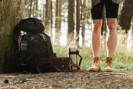 Female legs and hikers backpack on the groundの写真素材