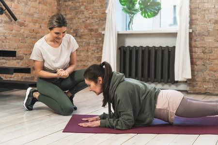 elderly woman during her fitness workout with personal trainer in gym