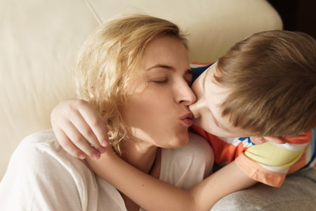Lovely mother and son kissing her at homeの写真素材