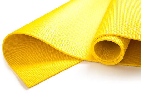 Closeup of yellow fitness mat on white backgroundの写真素材