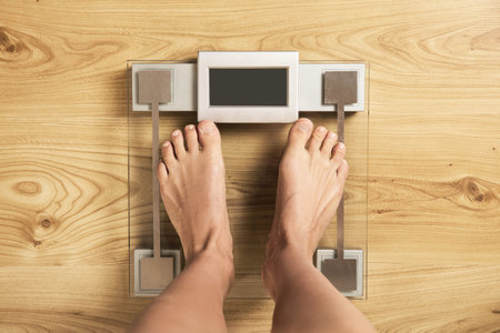 Female feet on the modern digital weighing scale