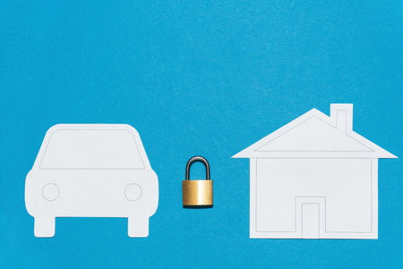 Yellow metallic lock between shapes of paper car and houseの写真素材