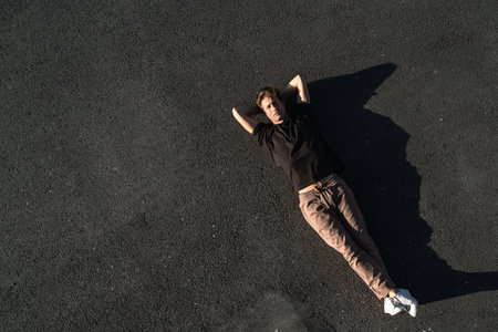 Top view of young man carefree lying on the asphaltの写真素材