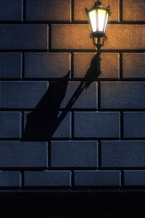 Street lantern on the stone block wall at nightの写真素材