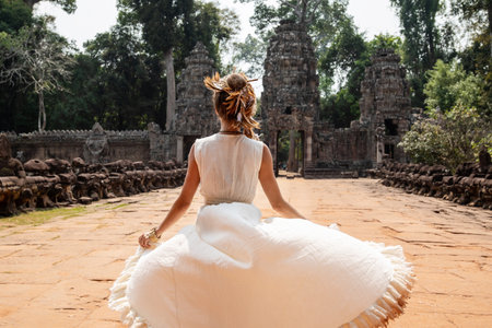 Young woman wearing white robe dress in ancient Khmer ruins, Angkor Watの写真素材