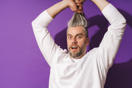 Silly middle aged man fooling around against purple backgroundの写真素材