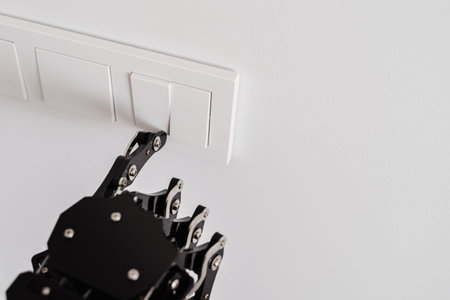Real robots hand pressing button on a light switch. Concept of robotic process automation