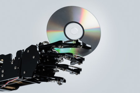Real robotic hand with compact disc. Concepts of AI development and data storageの写真素材