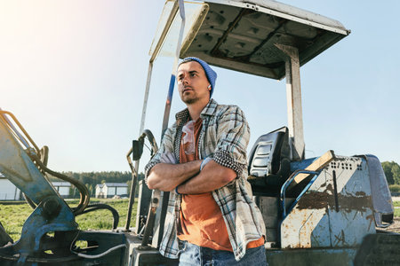 Young man standing near his old excavator during work on a construction siteの写真素材