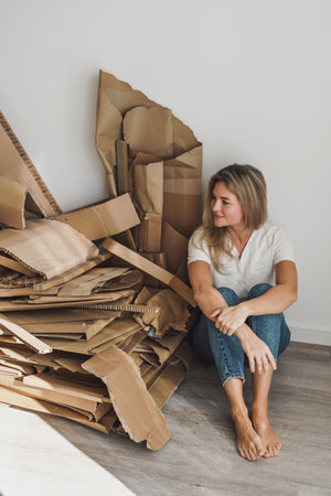 Young woman wand stack of cardboard waste at home. Concepts of Paper Recycling and Waste Sortingの写真素材
