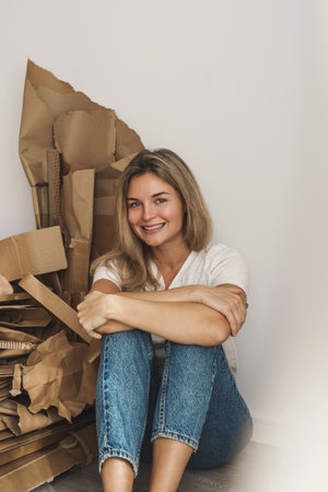 Young woman wand stack of cardboard waste at home. Concepts of Paper Recycling and Waste Sortingの写真素材