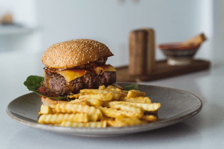 Delectable homemade cheeseburger on a plate accompanied by golden crispy French fries