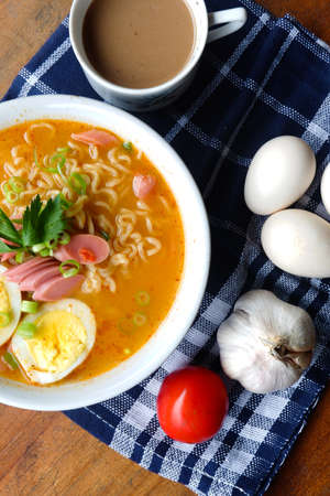 Photo of noodle soup with toppings such as sausages, eggs, and vegetablesの写真素材