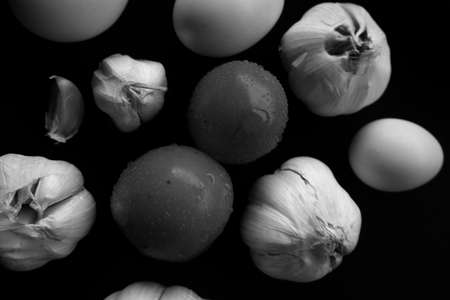 Egg and garlic photo on black backgroundの写真素材