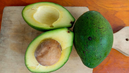 A photo of an avocado that has been split on a table