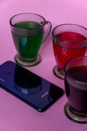 Photo of colorful drinks and smartphones on a pink backgroundのeditorial素材