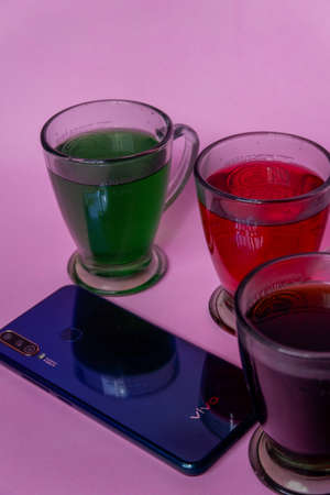 Photo of colorful drinks and smartphones on a pink backgroundのeditorial素材