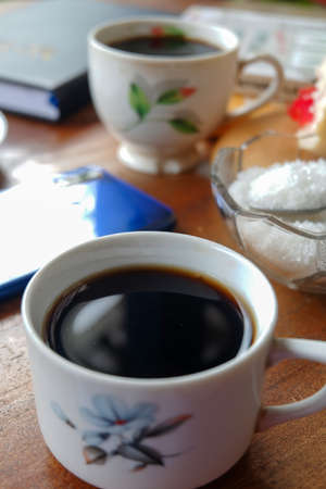 Close-up photo of someone drinking tea in the front yard of his houseのeditorial素材