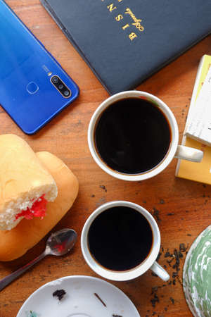 Close-up photo of someone drinking tea in the front yard of his houseのeditorial素材