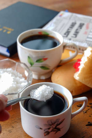 Close-up photo of someone drinking tea in the front yard of his houseのeditorial素材