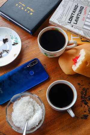 Close-up photo of someone drinking tea in the front yard of his houseのeditorial素材