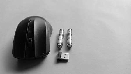 Photo of a wireless mouse with battery and usb next to it on a blue backgroundのeditorial素材