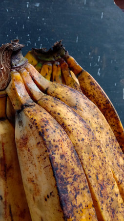 A banana with a close-up, against a black background, A banana fruit with a golden yellow color with a few spots indicating that the fruit is ripeの写真素材