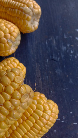 This photo of young sweet corn in yellow on a black background was taken from a close-up,...