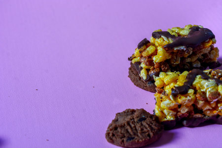 Close-up of choco chips and choco nuts on a purple background.