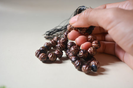Close up view of brown prayer beads on white background.