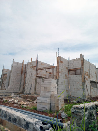 Partially built concrete structure with exposed walls and construction materials aroundの写真素材