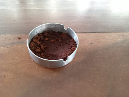 Brown coffee grounds left inside a circular metal filterの写真素材