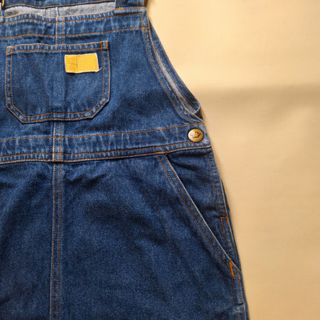 Blue denim overalls showing stitching details and small chest pocketの写真素材