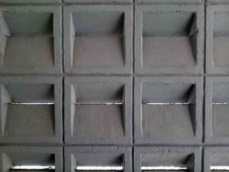 Concrete wall with geometric square indents and small ventilation gapsの写真素材
