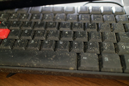 Old computer keyboard covered with visible dust particles and dirt buildupの写真素材