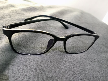 Closeup of eyeglasses placed on textured blanket surfaceの写真素材