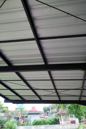 Black metal framing supports the wavy textured rooftop outsideの写真素材