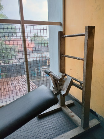 Worn out workout equipment beside window with rooftop view outsideの写真素材