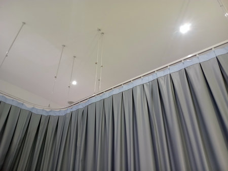 Blue and grey privacy curtains attached to ceiling frame rodsの写真素材